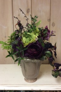 $45  WK-404   Light brown ceramic pot with burgundy and green Ranunculus
